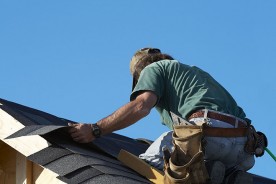 a roofing contractor installing asphalt roof shingles