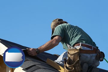 a roofing contractor installing asphalt roof shingles - with Pennsylvania icon